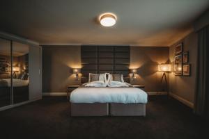 コッゲスホールにあるThe Essex Golf & Country Club Hotelのベッドルーム1室(大型ベッド1台、ランプ2つ付)