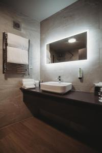 ein Bad mit einem Waschbecken und einem Spiegel in der Unterkunft The Essex Golf & Country Club Hotel in Coggeshall