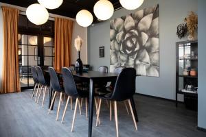 a dining room with a black table and chairs at Bob W Østerbro Copenhagen in Copenhagen