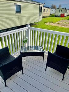 two chairs and a glass table on a deck at Sand Le Mere E11 in Beverley