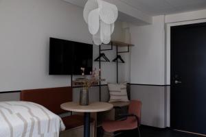 a room with a table and a bed and a tv at Bob W Østerbro Copenhagen in Copenhagen