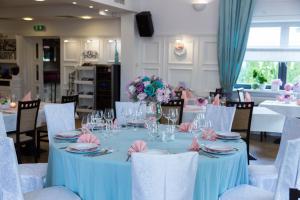 a table with a blue table cloth and flowers on it at Villa Aromat in Włoszczowa