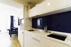 uma cozinha com armários brancos e uma parede azul em Elite Class Sea View Aparthotel In Orbi City Batumi em Batumi