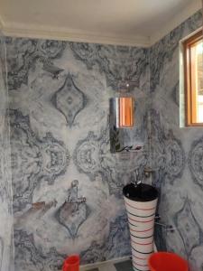 uma casa de banho com uma parede em mármore e um lavatório. em Dream River Guest House em Pahalgam
