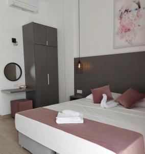 a bedroom with a large bed with towels on it at Lantiana Gardens ApartHotel in Protaras