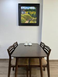 un tavolo di legno e due sedie davanti a un dipinto di Rental Apartment - LEVUHOUSE a Nha Trang