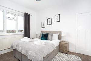 - une chambre avec un lit et 2 serviettes dans l'établissement Large 4 Bed in Southend, near shops/cafés/beach!, à Southend-on-Sea