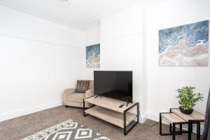 een woonkamer met een tv en een bank bij Large 4 Bed in Southend, near shops/cafés/beach! in Southend-on-Sea