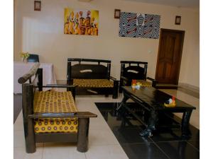 Igitego Hotel Remera في كيغالي: غرفة بها كراسي وطاولة