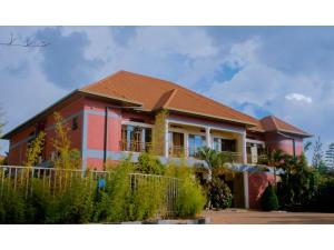 une maison avec une clôture devant elle dans l'établissement Igitego Hotel Remera, à Kigali