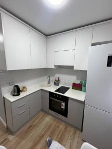 a small kitchen with white cabinets and a sink at Квартира in Sätbaev