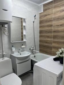 Baño blanco con lavabo, aseo y espejo en Квартира, en Sätbaev