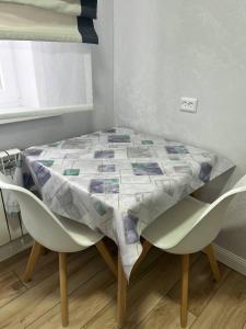 a table with two chairs and a quilt on it at Квартира in Sätbaev