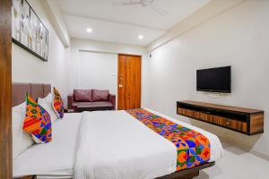 um quarto com uma cama grande e uma televisão de ecrã plano em FabHotel La Victoria em Surate