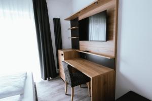 a bedroom with a desk with a mirror and a bed at Hotel am Park Bad Driburg in Bad Driburg