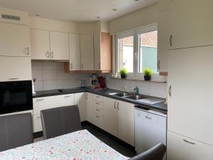 a kitchen with white cabinets and a sink at Vakantie-woning in Sint Kruis