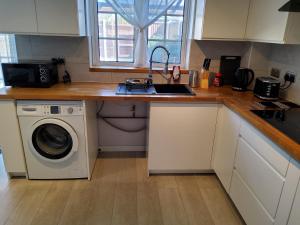 a kitchen with a sink and a washing machine at Impeccable 2-Bed House in Norwich in Norwich