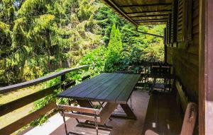 a picnic table and benches on the porch of a house at 3 Bedroom Beautiful Home In Studzienice in Studzienice