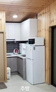 a kitchen with white cabinets and a white refrigerator at Seoneulgimunhwa in Yeongju