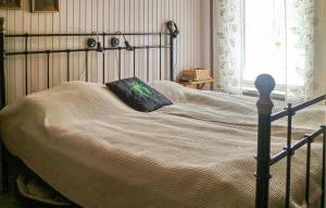 Una cama con marco negro y una almohada. en Beautiful Home In Leksand With Wifi, en Leksand