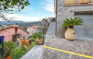 un cane in piedi dietro una recinzione di fronte a una casa di 2 Bedroom Awesome Apartment In Moneglia a Moneglia