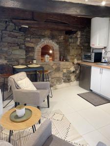 uma cozinha e sala de estar com uma parede de pedra em Ar Maen em Lanvollon