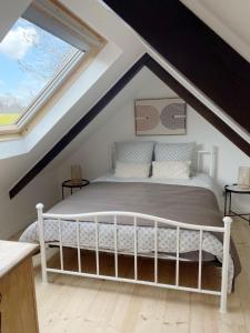 een slaapkamer met een wit bed op zolder bij Ar Maen in Lanvollon