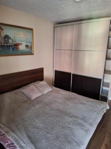een slaapkamer met een bed met een houten hoofdeinde bij Appartment in Zenica