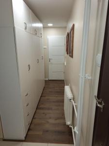 a hallway with white cabinets and a white door at Appartment in Zenica