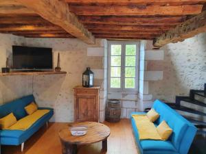 a living room with two blue couches and a table at Maison superbe sur 2 étages avec piscine in Celles