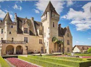 a large castle with pink flowers in front of it at Maison superbe sur 2 étages avec piscine in Celles