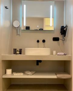 a bathroom with a sink and a mirror at Asteras Mini Suites in Naousa