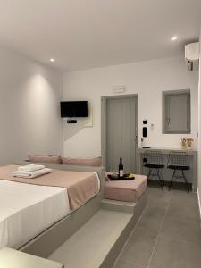 a bedroom with two beds and a flat screen tv at Asteras Mini Suites in Naousa