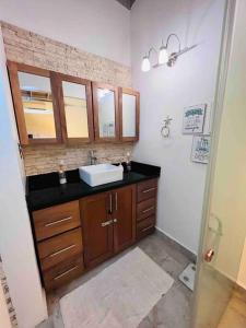 ein Badezimmer mit einem Waschbecken und einer Arbeitsplatte in der Unterkunft Casa en Villas Jubey con acceso al Hotel Emotion By Hodelpa in Juan Dolio