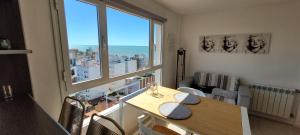 a room with a table and a large window at La Perla I in Mar del Plata