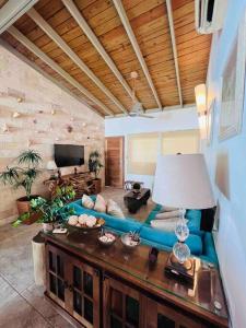 Casa en Villas Jubey con acceso al Hotel Emotion By Hodelpa في خوان دوليو: غرفة معيشة مع أريكة زرقاء وطاولة
