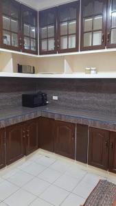 a kitchen with wooden cabinets and a counter top at Loidas Place in Talisay