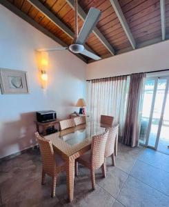 a dining room with a table with chairs and a ceiling fan at Casa en Villas Jubey con acceso al Hotel Emotion By Hodelpa in Juan Dolio