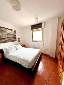 1 dormitorio con cama y ventana en Apartamento Playa Merón, en San Vicente de la Barquera