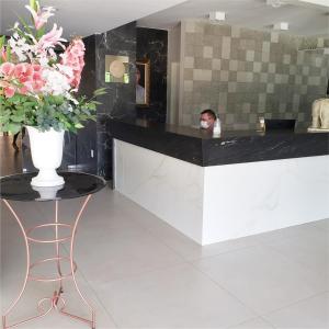 a person wearing a mask behind a counter in a room with flowers at Picos Hotel in Picos