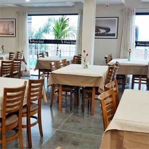 a restaurant with tables and chairs and a large window at Picos Hotel in Picos