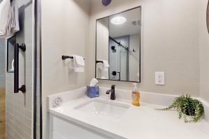 ein Badezimmer mit einem weißen Waschbecken und einem Spiegel in der Unterkunft Romantic River Cabin #3475 in Estes Park