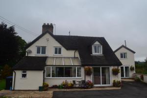 uma casa branca com um telhado preto em The Lilacs em Ashbourne