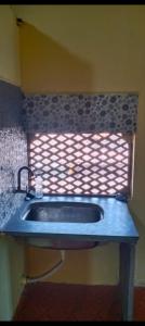 - Baño con lavabo y ventana en Om Laxmi Narayan Homestay, en Diveagar