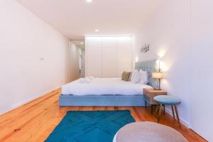a bedroom with a large bed and a blue rug at Outstanding Santos Spacious 2 Bedroom Apt w AC in Lisbon