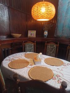 a table with four chairs and a chandelier at Hotel-hostel Saska in Warsaw