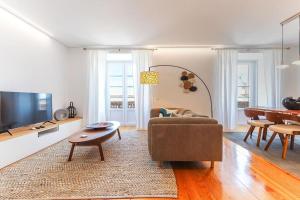 a living room with a couch and a table at Outstanding Santos Spacious 2 Bedroom Apt w AC in Lisbon