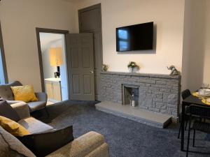 a living room with a fireplace with a flat screen tv at Rectory4 -Lovely 4 Bdrm 6 Beds Gateshead Free Parking in Gateshead