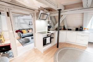 uma cozinha e sala de estar com armários brancos em XZLLENZ: Exquisit, Fachwerk, Dachterrasse - Wohlfühlen em Schwabach