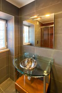 a bathroom with a glass sink and a mirror at Casa da Luz - Country House with Terrace in Semide